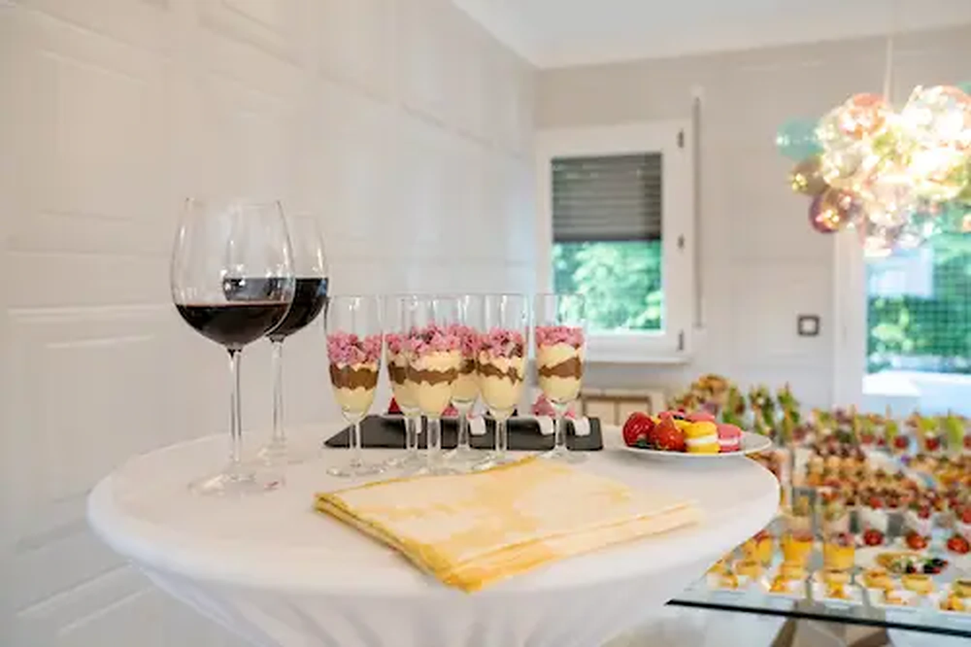 Stehtisch mit Dessertgläsern und Wein im Salon